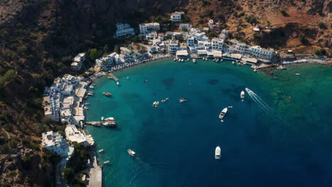 Barcos-Y-Yates-Flotando-En-El-Mar-Azul-Claro-Cerca-De-La-Playa-Y-El-Pueblo-De-Loutro-En-Creta,-Grecia