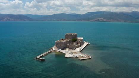Bourtzi-Fortress,-a-prison-in-the-sea-in-front-of-Nafplio-town-the-first-capital-of-Greece---aerial-drone-shot