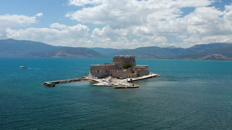 Aerial-View-Of-Bourtzi-Castle-In-Middle-Of-Calm-Blue-Sea-Near-Nafplio-In-Peloponnese,-Greece