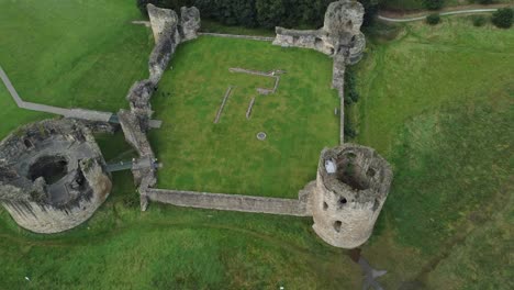 Flint-castle-Welsh-medieval-coastal-military-fortress-ruin-aerial-view-descending-tracking-shot