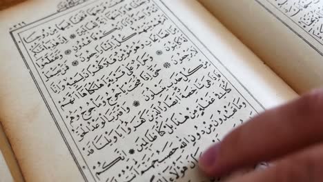 Hands-turning-the-pages-of-the-Quran-reading-and-browsing-the-book