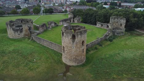 Flint-castle-Welsh-medieval-coastal-military-fortress-ruin-aerial-view-left-rotating-above-tower