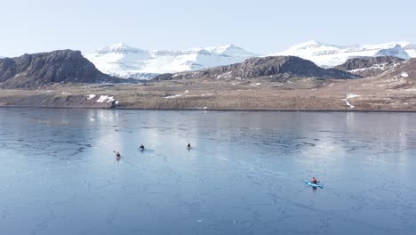 Adventure-kayakers-exploring-cold-fjord-waters-in-East-Iceland,-aerial