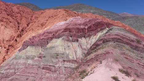 Drone-flight-above-The-Hills-of-Seven-Colors-showing-red,-purple,-orange,-lilac,-ocher-and-beige-colors-in-Jujuy-Province,-Argentina