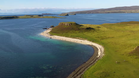 Rotating-drone-shot-of-Coral-Beach-in-Claigan-with-white-sandy-beaches-and-tropical-blue-water,-in-Scotland