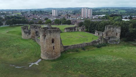 Flint-castle-Welsh-medieval-coastal-military-fortress-ruin-aerial-view-rising-pull-away-establishing-shot