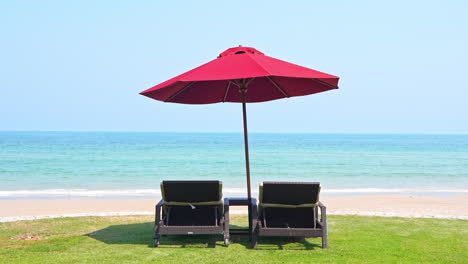 Empty-Beach,-Two-Beach-Beds-and-Umbrella-in-Front-of-Tropical-Sea-and-Horizon
