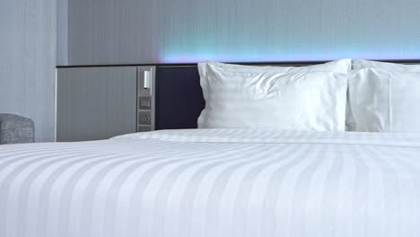 Double-bed-with-white-candid-sheets-and-pillows-in-hotel-room