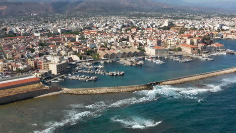 Wellen,-Die-Im-Hafen-Von-Chania-Auf-Der-Insel-Kreta,-Griechenland,-Mit-Blick-Auf-Den-Jachthafen-Und-Die-Häuser-Am-Meer-Plätschern