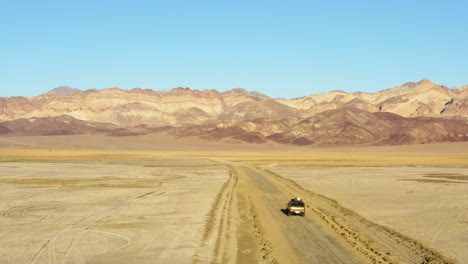 SUV-jeep-on-road-amidst-hot-dry-barren-terrain-of-Death-valley-national-park