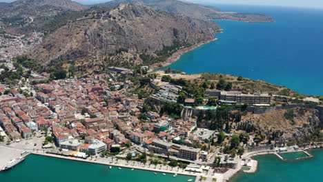 Aerial-View-Of-Coastal-City-Of-Nafplio-In-The-Peloponnese-Peninsula-In-Greece-With-Fortress-On-Hilltop-In-Background