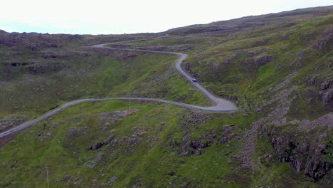 Revealing-drone-shot-of-twisting-road-on-Bealach-Na-Ba-Applecross-road-through-the-mountains-of-the-Applecross-peninsula,-in-Wester-Ross-in-the-Scottish-Highlands