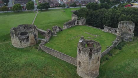 Flint-castle-Welsh-medieval-coastal-military-fortress-ruin-aerial-view-slow-tracking-top-down-shot