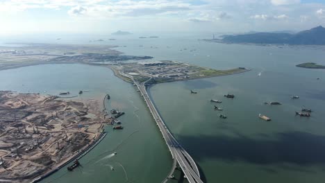 Commercial-airplane-taking-off-at-Hong-Kong-Zhuhai-Macau-Bridge-on-a-beautiful-day,-wide-angle-aerial-view