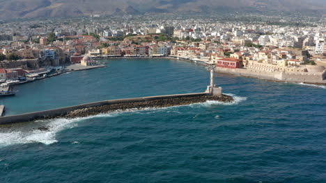 Waves-Crashing-On-Breakwater-Of-Old-Venetian-Port-Of-Chania-With-Lighthouse-In-Crete,-Greece
