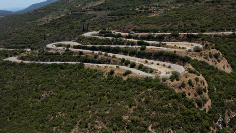 Aerial-View-Of-Vehicles-Driving-Down-On-Winding-Road-By-The-Mountain-In-Peloponnese,-Greece