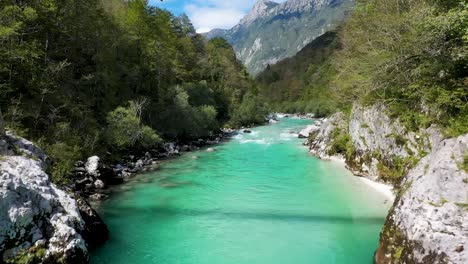 Emerald-green-river-with-a-hanging-bridge-in-a-canyon-surrounded-by-forest