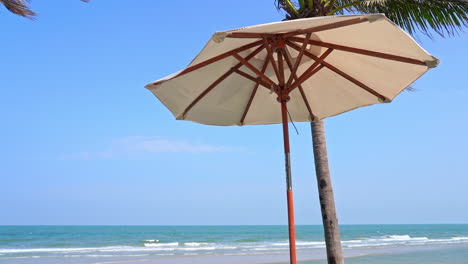 Ein-Sonnenschirm-Am-Strand-Und-Kokospalmen-Direkt-Am-Strand-Der-Insel-Mit-Ebbe-Auf-Sand