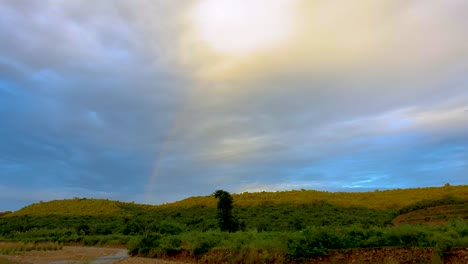 Atemberaubende-Aussicht-Auf-Mutter-Natur-Mit-Regenbogen-Hinter-Bergen-Bei-Bewölktem-Himmel