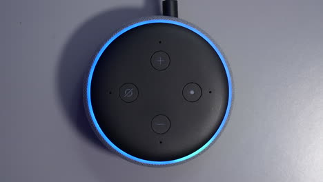 Overhead-shot-of-smart-speaker-activated-by-voice-command-control-with-blue-light-ring
