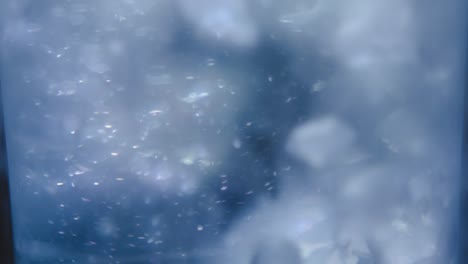 Close-up-motion-stacked-ice-cubes-collapsing-with-bubbles-underwater