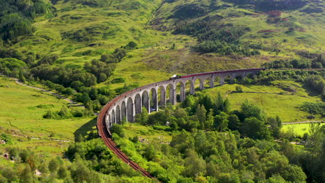 Rotating-drone-shot-of-train-on-famous-railroad-bridge-in-the-Glenfinnan-Viaduct