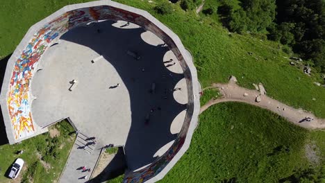 Cinematic-drone-shot-from-top-down,-zooming-out-from-an-ancient-monument-in-Georgia-in-front-of-beautiful-mountains