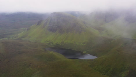 Cinematic-drone-shot-coming-through-the-clouds-to-reveal-Quiraing-the-landslip-on-the-eastern-face-of-Meall-na-Suiramach-in-Scotland