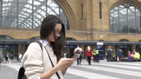 Frau-Stand-Mit-Ihrem-Smartphone-Außerhalb-Der-Londoner-Kings-Cross-Station