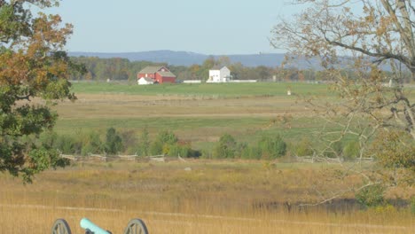 Wide-open-view-of-the-battlefield-of-Gettysburg-with-a-cannon-in-first-term-and-a-red-barn-on-the-horizon