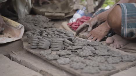 Unrecognized-hands-of-poor-sculptor-making-clay-pots-and-idols,-slow-motion