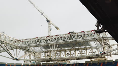 Tower-Crane-Working-On-Roof-Structure-Of-A-Football-Stadium-Being-Constructed-In-Madrid,-Spain