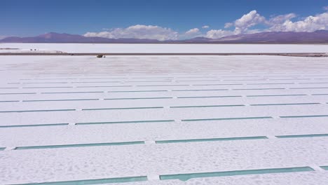 Salt-extraction-machine-working-in-the-salt-pools-of-the-Salina-Grande-de-Jujuy-in-Argentina-with-a-mountainous-volcanic-landscape-at-the-background