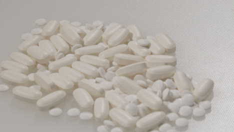 Close-Dolly-of-various-pills-on-a-white-surface