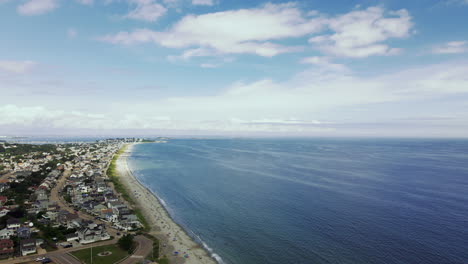 Aerial-footage-of-drone-descending-to-urban-beach-area-on-a-perfect-summer-day