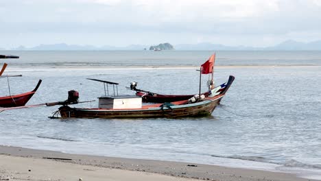 Blick-Auf-Fischerboote,-Die-Tagsüber-An-Einem-Windgepeitschten-Strand-In-Südthailand-Festgemacht-Sind