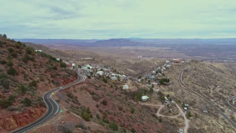 Aerial-coming-around-hillside-to-reveal-small-town-Jerome-Arizona,-4K
