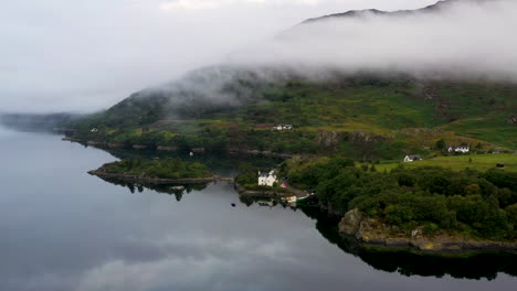 Wide-descending-drone-shot-of-Loch-Carron-with-low-lying-clouds,-in-the-Scottish-Highlands