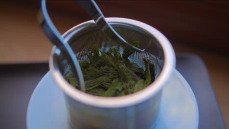 Soak-Green-Taiping-Houkui-Tea-Leaves-On-A-Metal-Filter