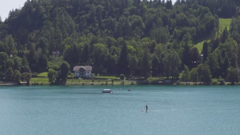 Ein-Einsamer-Stand-Up-Paddle-Boarder-Paddelt-Im-Bleder-See,-Slowenien