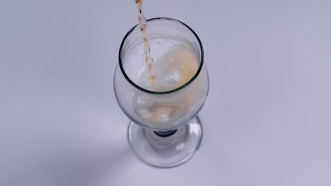 Beer-is-pouring-into-glass-on-white-background