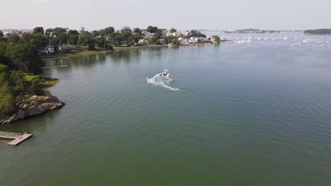 Flying-Towards-A-Water-Skier-Towed-By-A-Speedboat-Across-Cohasset-Harbor-In-Massachusetts