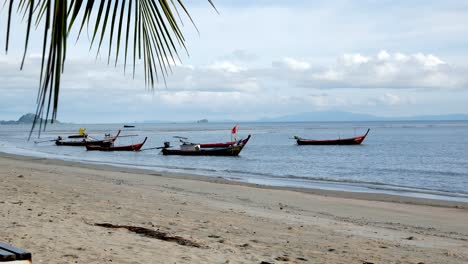 Fischerboote,-Die-Tagsüber-An-Einem-Windgepeitschten-Strand-In-Südthailand-Festgemacht-Sind