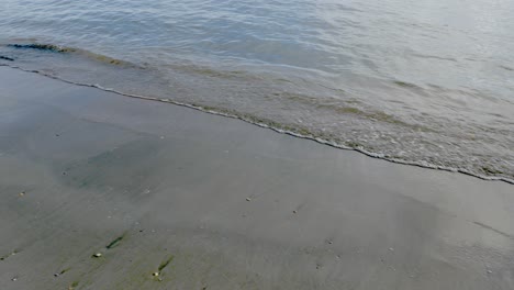 Sanfte-Meereswellen,-Die-An-Einem-Goldfarbenen-Sandstrand-Plätschern