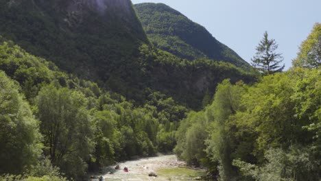 Eine-Gruppe-Von-Kajakfahrern,-Die-Den-Soča-fluss-In-Slowenien-Vor-Einer-Dramatischen-Bergkulisse-Hinunterfahren