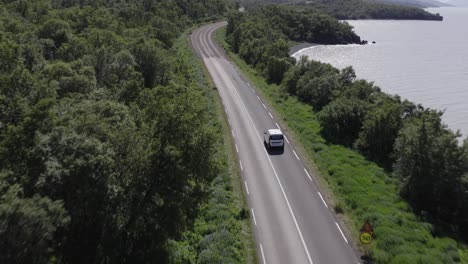Weißes-Auto,-Das-Auf-Abgelegener-Straße-In-Island-Durch-Natürlichen-Wald-Und-See-Fährt