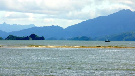 View-of-the-seaside-overlooking-the-sea-and-mountains-with-gentle-waves-on-a-holiday-in-good-weather,-Satun-Province,-Thailand