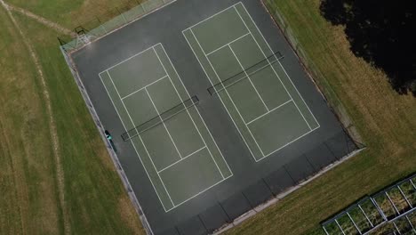 a-steady-and-still-tripod-shot-of-a-large-tennis-court-in-the-middle-of-the-countryside-in-england,-happy-vibes-all-the-way-to-goodness,-this-video-was-shot-on-the-DJI-drone-at-1080p-FHD