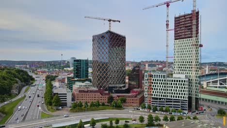 Tráfico-Circulando-Por-La-Carretera-Que-Pasa-Por-Citygate-Y-Kineum-Edificio-De-Gran-Altura-En-Construcción-En-Gotemburgo,-Suecia