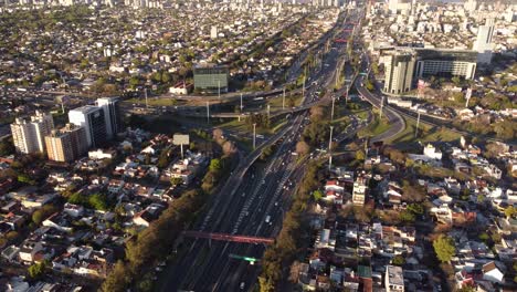 Aerial-flyover-cityscape-in-Buenos-Aires-and-Traffic-on-Pan-American-Highway-during-sunset---High-angle-panorama-shot